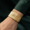 Vela — Gold Ribbed Cuff Bracelet worn on wrist Vela — Gold Ribbed Cuff Bracelet worn on wrist