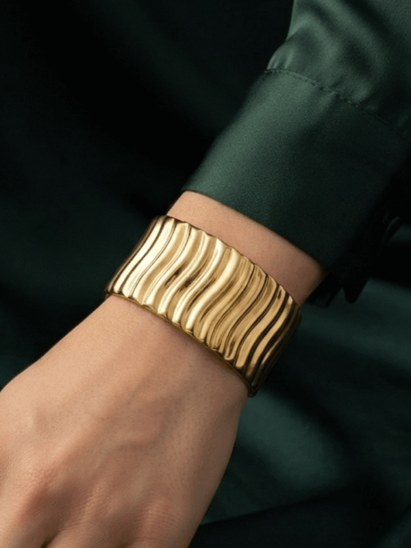Vela — Gold Ribbed Cuff Bracelet worn on wrist Vela — Gold Ribbed Cuff Bracelet worn on wrist
