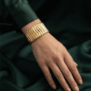 Vela — Gold Ribbed Cuff Bracelet worn on wrist Vela — Gold Ribbed Cuff Bracelet worn on wrist