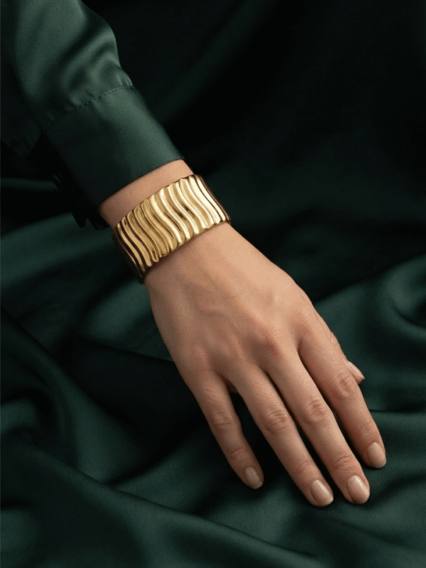 Vela — Gold Ribbed Cuff Bracelet worn on wrist Vela — Gold Ribbed Cuff Bracelet worn on wrist