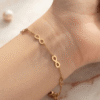 Infini — Gold Infinity Link Bracelet worn on wrist Infini — Gold Infinity Link Bracelet worn on wrist