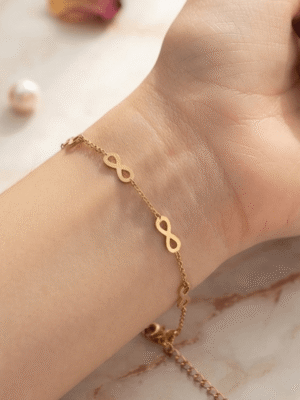 Infini — Gold Infinity Link Bracelet worn on wrist Infini — Gold Infinity Link Bracelet worn on wrist